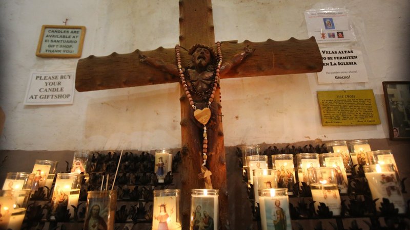 Candles surround a crucifix in the historic El Santuario de Chimayo Church in Chimayo, N.M., July 29, 2020. (CNS photo/Bob Roller)