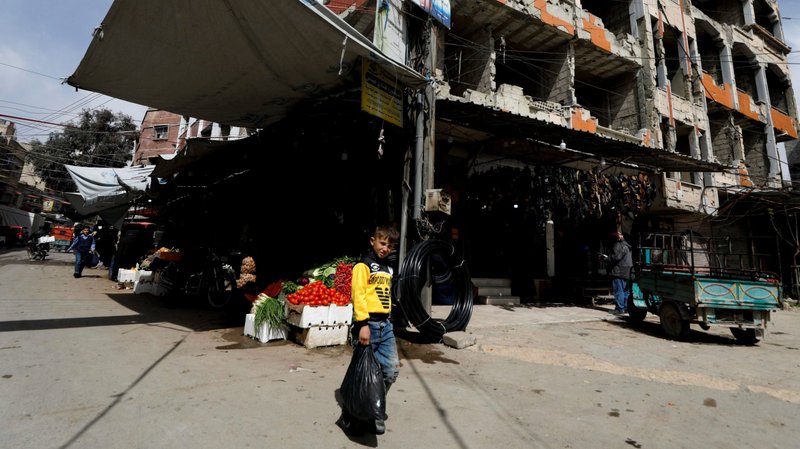A boy walks past damaged buildings in Douma, Syria, March 10, 2021. All sides need to come together to end the war in Syria and bring some sign of hope to an exhausted and tormented people, Pope Francis said during the March 14 Angelus. (CNS photo/Omar Sanadiki, Reuters)