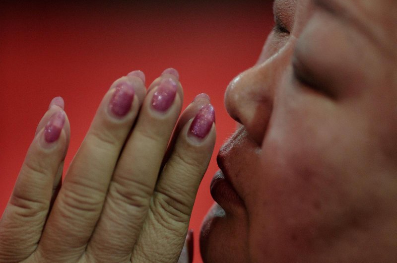A woman prays during Holy Thursday Mass March 29, 2018, at the Cathedral of the Immaculate Conception in Beijing. Cardinal Charles Bo of Yangon, Myanmar, head of the Federation of Asian Bishops' Conferences, has designated May 23-30 as a week of prayer for China. (CNS photo/Damir Sagolj, Reuters)