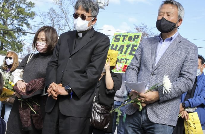 Father Kolbe Chung, pastor at St. Andrew Kim Church in Duluth, Ga., and and Joseph Nam attend an interfaith prayer service at Gold Spa March 21, 2021, following the deadly shootings March 16 at three Asian day spas in metro Atlanta. (Michael Alexander/The Georgia Bulletin, via CNS)