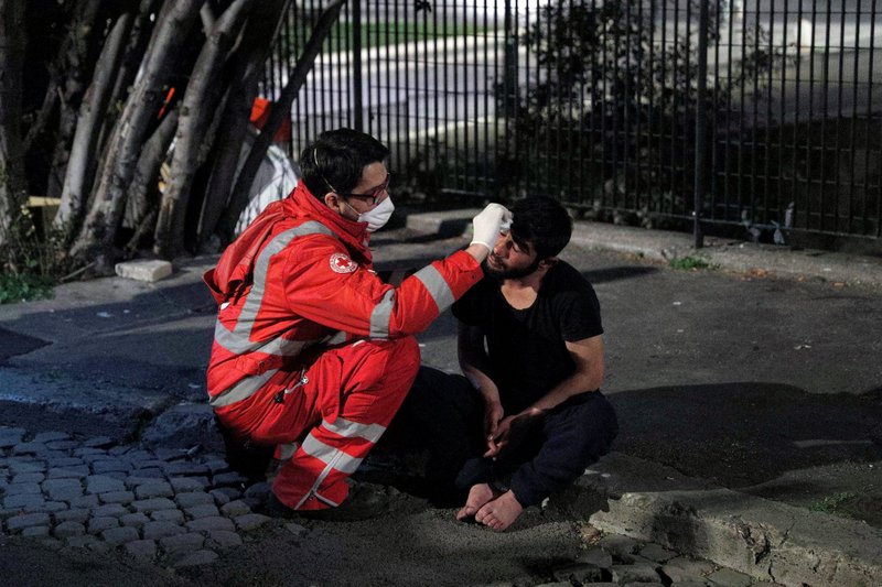 A homeless person is treated by a Red Cross worker in Rome March 17, 2020, during the COVID-19 pandemic. The Office of Papal Charities has purchased enough doses of the Pfizer-BioNTech vaccine to offer inoculations in Rome to 1,200 of "the poorest and most marginalized people who, because of their situation, are the most exposed" to COVID-19. (CNS photo/Guglielmo Mangiapane, Reuters)