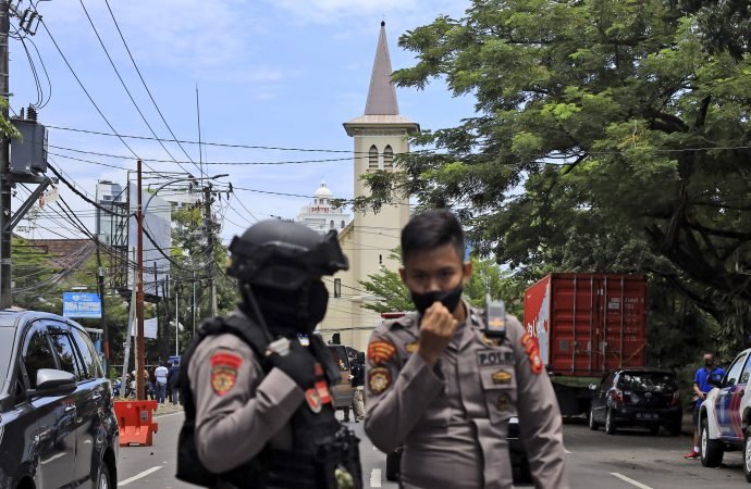 Police officers guard near a church where an explosion went off in Makassar, South Sulawesi, Indonesia, Sunday, March 28, 2021. (Yusuf Wahil/AP via Crux)