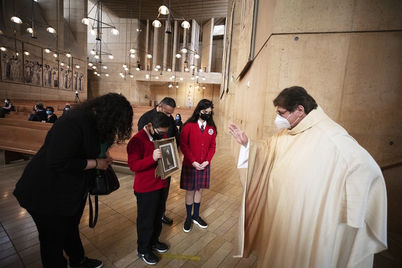 Mia (seventh grade) and Marcos (fourth grade) Duarte have an image of St. Joseph blessed by Father Beto Villalobos, pastor of St. Joseph the Worker in Winnetka, where they attend school. (Victor Alemán)