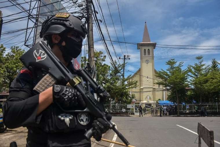 An Indonesian policeman stands guard outside a church after an explosion in Makassar on March 28, 2021. (Indra Abriyanto/AFP via Getty Images)