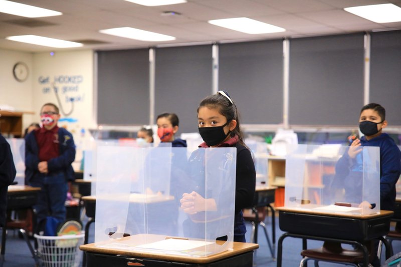 Second graders stand behind Plexiglass shields. (David Amador Rivera)