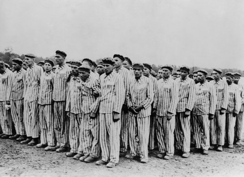 Roll call at Buchenwald concentration camp, circa 1938-1941. Two prisoners in the foreground are supporting a comrade, as fainting was frequently an excuse for the guards to "liquidate" useless inmates. (Everett Collection/Shutterstock)