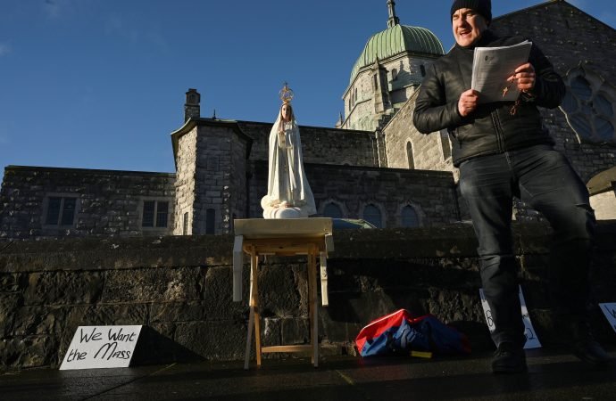 A man participating in a rosary rally prays near a statue of Mary on New Year's Day outside the cathedral in Galway, Ireland, Jan. 1, 2021. He was asking for the return of public Mass during the COVID-19 pandemic. (Clodagh Kilcoyne/Reuters via CNS)