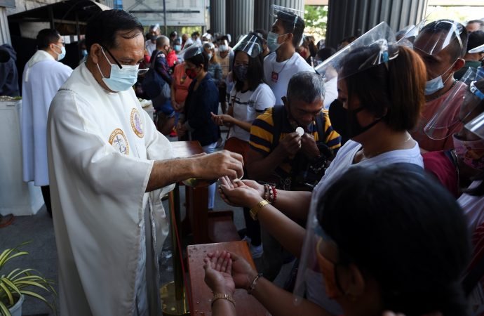 A priest wearing a protective mask distributes Communion during Easter Mass at St. Peter Parish: Shrine of Leaders in Manila, Philippines, April 4, 2021, during the COVID-19 pandemic. Pope Francis delivered a video message to the people of the Philippines as they open a jubilee year to mark the 500th anniversary of the arrival of Christianity in their country. The message was aired April 4. (Lisa Marie David/Reuters via CNS)