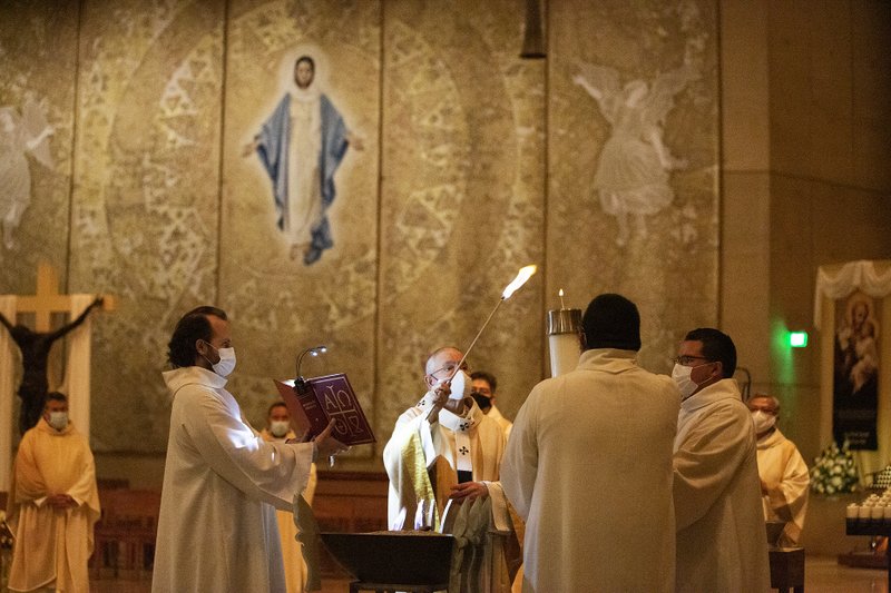 Archbishop José H. Gomez lights the Paschal candle at the Easter Vigil at the Cathedral of Our Lady of the Angels the night of April 3, 2021. (Victor Alemán)