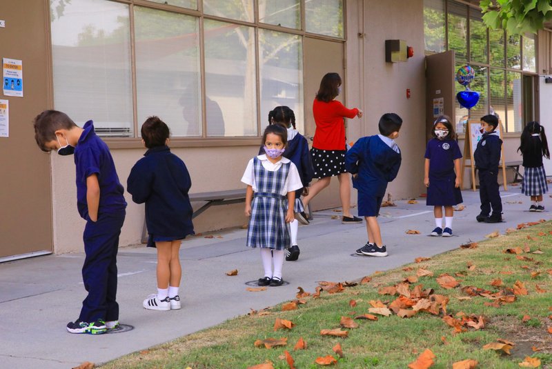 Catholic school students in Long Beach line up on distance markers at school in October 2020. (David Amador Rivera)