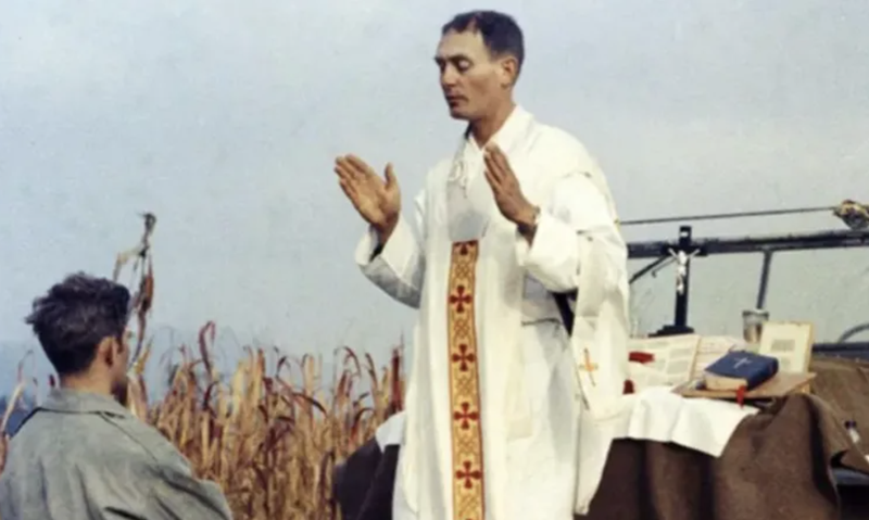 Father Emil Kapaun celebrates Mass using the hood of a Jeep as his altar on Oct. 7, 1950. (Public Domain)