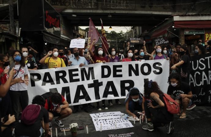 Activists and victim's relatives light candles and hold the Portuguese message: "Stop killing us" the day after a deadly police operation in the Jacarezinho favela of Rio de Janeiro, Brazil, Friday, May 7, 2021. A bloody, hours-long gunbattle here echoed into Friday, with authorities saying the police mission killed two dozen criminals while residents and activists claimed human rights abuses. (Silvia Izquierdo/AP via Crux)