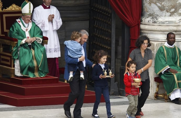 Pope Francis watches as a family carries offertory gifts to the altar during a Mass for catechists in St. Peter's Square at the Vatican in this Sept. 29, 2013, file photo.(Paul Haring/CNS)