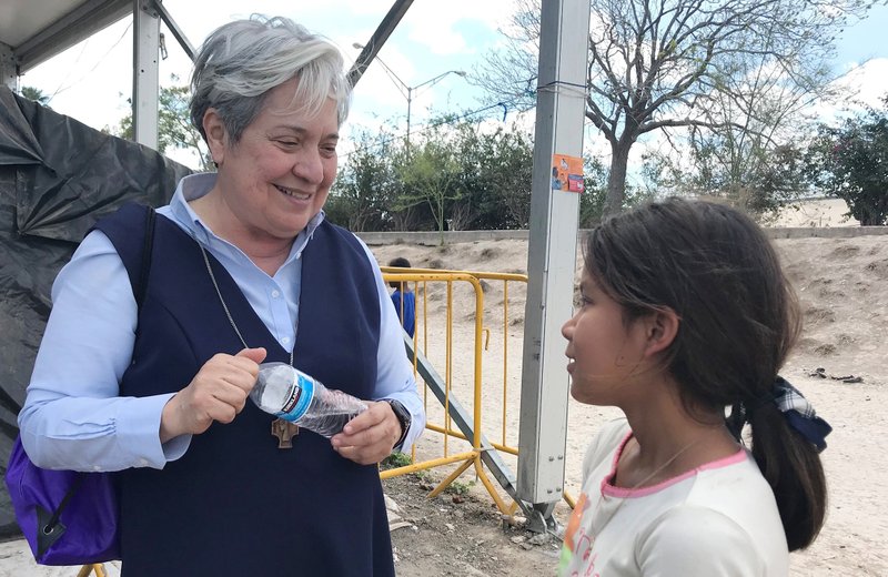 Sister Norma Pimentel, director of Catholic Charities of the Rio Grande Valley in Texas, speaks with a young resident of a tent camp in Matamoros, Mexico. (CNS photo/David Agren)