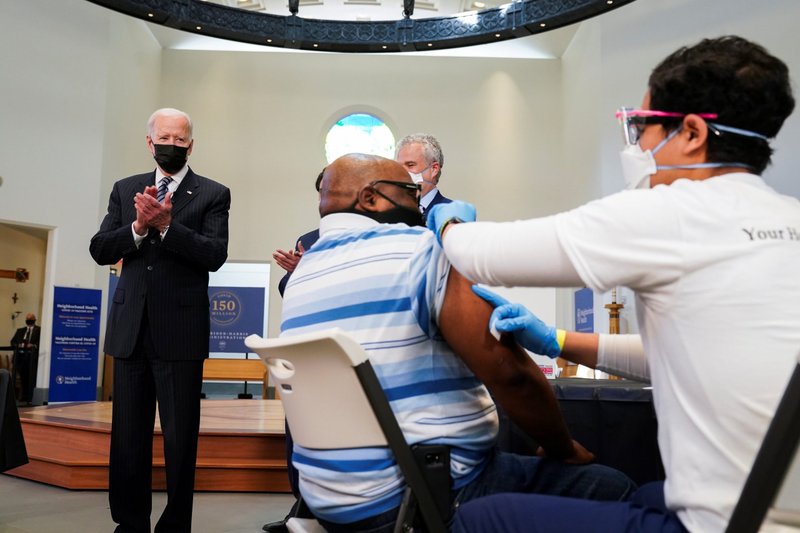President Joe Biden applauds a man receiving the COVID-19 vaccine at Virginia Theological Seminary in Alexandria, Va., April 6, 2021. (CNS photo/Kevin Lamarque, Reuters)