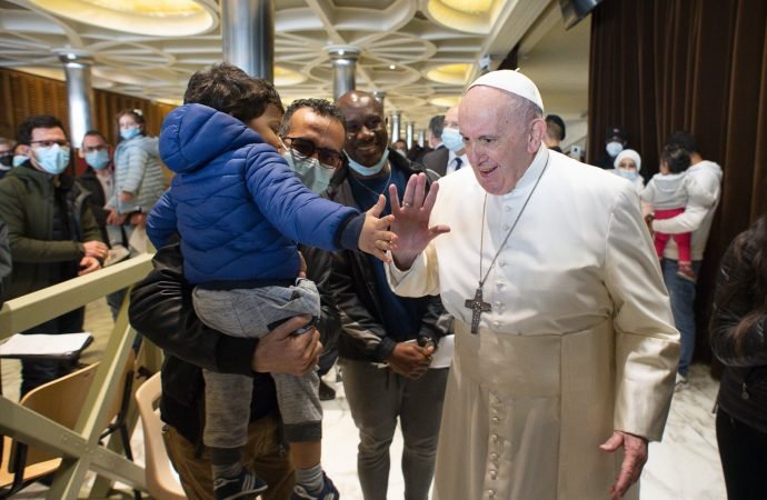 Pope Francis greets a child as he visits people who came to the Vatican for the second dose of their COVID-19 vaccinations in the Paul VI hall at the Vatican April 23, 2021. (CNS photo/Vatican Media)