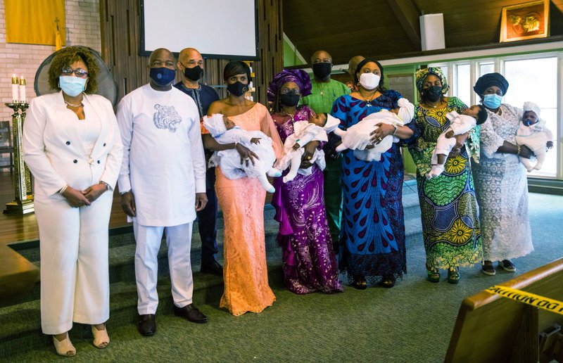 Patricia and Basil Eze, left, the parents of the quintuplets baptized at St. Matthias the Apostle Catholic Church in Lanham, Md., are joined by their babies and godparents April 25, 2021. (CNS photo/Andrew Biraj, Catholic Standard)
