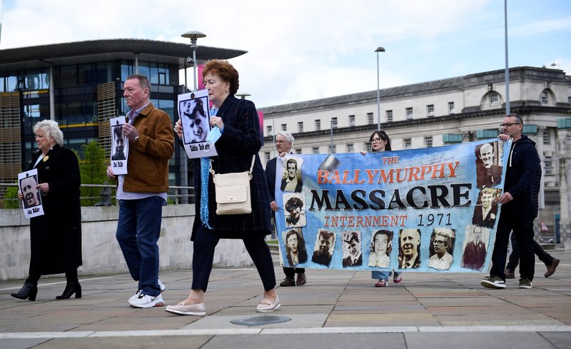 Family members of victims of the 1971 Ballymurphy Massacre hold their pictures and a banner as they arrive at an inquest in Belfast, Northern Ireland, May 11, 2021. A coroner ruled that 10 Catholics shot dead by British troops almost 50 years ago were "entirely innocent" and their deaths were unjustified. (CNS photo/Clodagh Kilcoyne, Reuters)