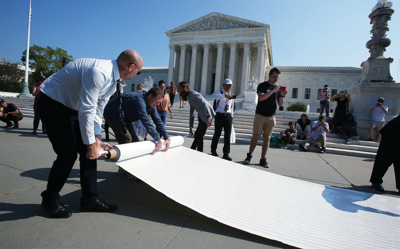 Pro-life leaders unfurl a petition in front of the U.S. Supreme Court in Washington Oct. 1, 2019, with more than 250,000 signatures calling for the court to overturn Roe v. Wade. This year, U.S. bishops are encouraging Catholics to sign a petition to oppose the Hyde Amendment's repeal. The Hyde Amendment would prevent federal funding for abortion as a permanent part of the law. (CNS photo/Tyler Orsburn)