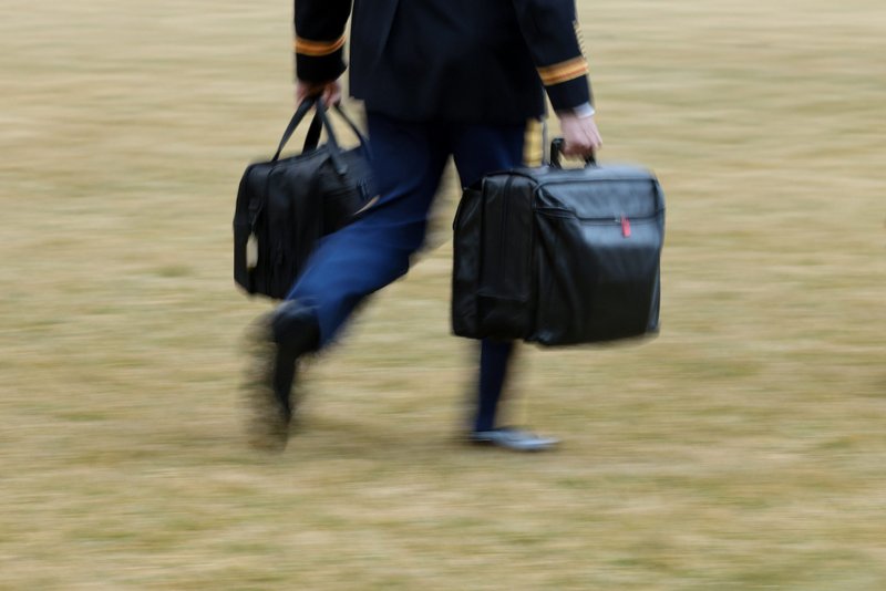 A White House military aide carries the so-called nuclear football as he walks to board the Marine One helicopter with President Joe Biden at the White House in Washington Feb. 16, 2021. (CNS photo/Jonathan Ernst, Reuters)