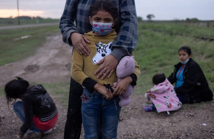 A migrant family from Honduras seeking asylum in the U.S. waits to be transported to a Border Patrol processing facility after crossing the Rio Grande into La Joya, Texas, May 13, 2021. (Adrees Latif/Reuters via CNS)