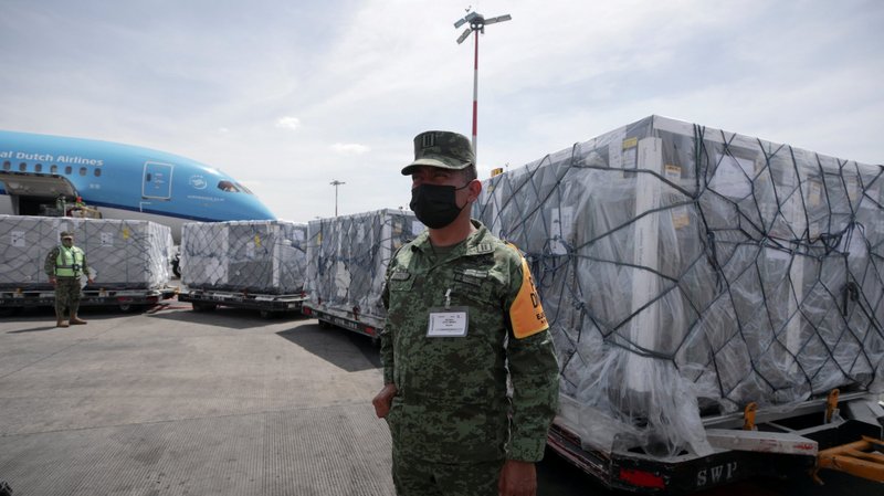A member of the National Guard looks on as a batch of AstraZeneca COVID-19 vaccines, delivered under the COVAX scheme, is unloaded from a plane at Benito Juarez International Airport in Mexico City May 27, 2021. In a joint statement, the heads of the bishops of the European Union and the U.S. released a joint message that mentioned their support of the COVAX initiative. (CNS photo/Henny Romero, Reuters)