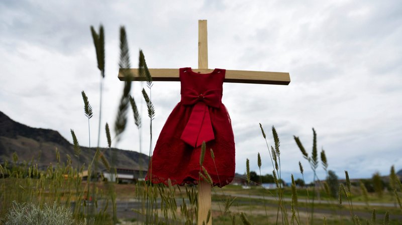 A child's red dress hangs on a cross near the grounds of the former Kamloops Indian Residential School in Kamloops, British Columbia, June 6, 2021. The remains of 215 children, some as young as 3 years old, were detected by ground-penetrating radar found at the site in May. (CNS photo/Jennifer Gauthier, Reuters)