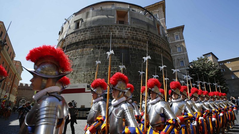 Swiss Guards march in front of the tower of the Institute for Works of Religion, commonly called the Vatican bank, in this May 6, 2014, file photo. Despite the COVID-19 pandemic, the Vatican bank had a profit of 36.4 million Euros ($44.1 million) in 2020, according to its annual report. (CNS photo/Tony Gentile, Reuters)