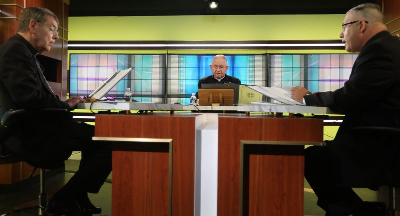 Msgr. Jeffrey D. Burrill, general secretary of the U.S. Conference of Catholic Bishops, right, reads a message to Pope Francis June 16, 2021, at the USCCB headquarters in Washington on the opening day of the bishops'three-day virtual spring meeting. Also pictured are Detroit Archbishop Allen H. Vigneron, USCCB vice president, and Archbishop José H. Gomez of Los Angeles, USCCB president. (CNS photo/CNS photo/Bob Roller)