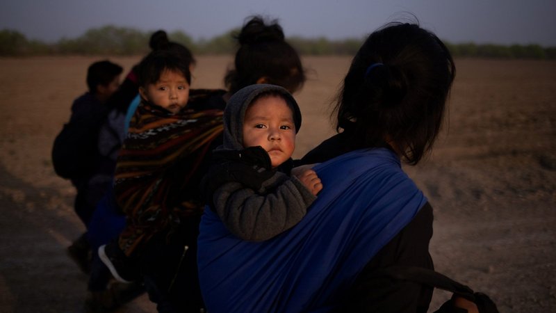 Migrants from Guatemala carry their children in Penitas, Texas, March 17, 2021, after crossing the Rio Grande. (CNS photo/Adrees Latif, Reuters)