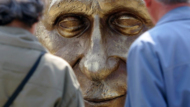People look at a sculpture of Robert Schuman, France's former foreign minister, at a park in Bucharest, Romania, in this May 9, 2006, file photo. Pope Francis has advanced the sainthood cause of Schuman, who helped lay the groundwork for the European Union. (CNS photo/Bogdan Cristel, Reuters)