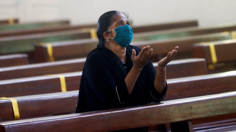 A woman wearing a protective mask prays inside a church in Mumbai, India, Nov. 16, 2020. The Pew Research Center has released its study on religion in India. (CNS photo/Francis Mascarenhas, Reuters)