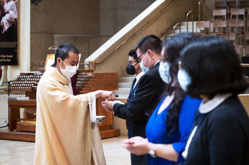 Father Gallardo distributes communion during the feast day Mass. (Victor Alemán)