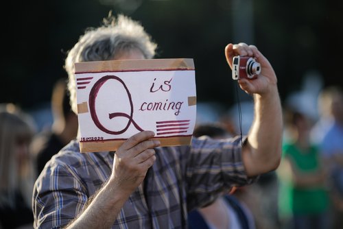 A man takes part in a protest in Romania, displaying a QAnon message, in 2020. (M.Moira/Shutterstock.com)