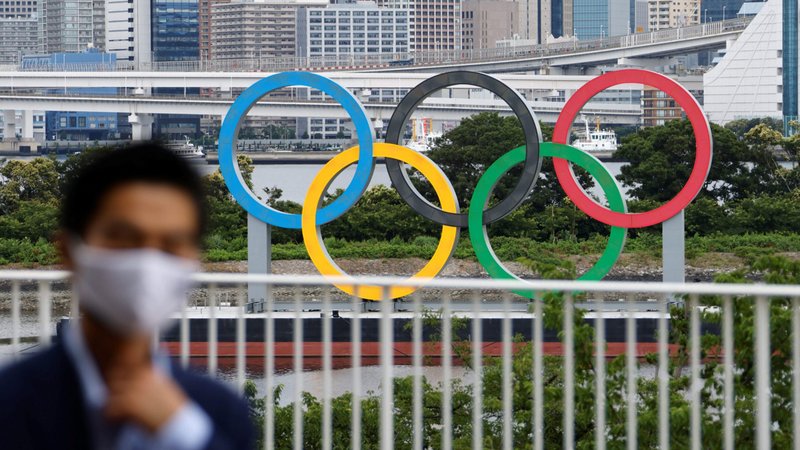 A man wearing a protective mask walks past the Olympic Rings in Tokyo June 27, 2021, ahead of the upcoming Olympic and Paralympic Games, postponed from 2020 due to the COVID-19 pandemic. (CNS photo/Fabrizio Bensch, Reuters)