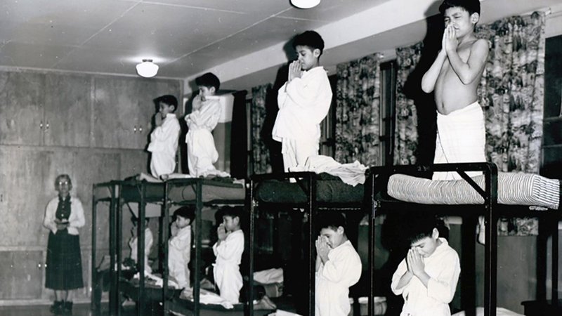 Indigenous boys pray on bunk beds in a dormitory at the Bishop Horden Memorial School, a residential school in the indigenous Cree community of Moose Factory, Ontario, in 1950. Recent confirmation of hundreds of unmarked graves on the grounds of two former residential schools for Indigenous children in Canada has prompted a U.S. Department of the Interior inquiry into U.S. boarding schools for Native Americans, which were often run by churches. (CNS photo/Shingwauk Residential Schools Centre, Handout via Reuters)