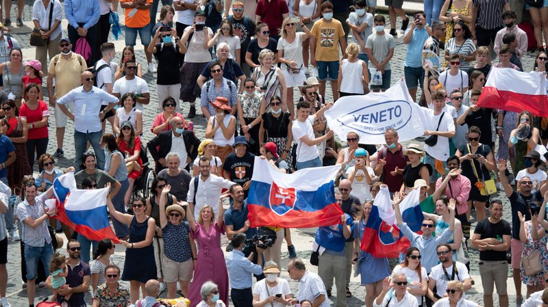 Pilgrims holding the Slovak flag cheer in St. Peter's Square at the Vatican July 4, 2021, as Pope Francis announces he will visit their country Sept. 12-15 after stopping in Budapest, Hungary, to celebrate the closing Mass of the International Eucharistic Congress. (CNS photo/Vatican Media)