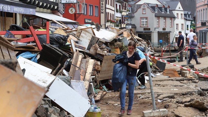 People walk through an area affected by flooding in Bad Münstereifel Germany, July 19, 2021. Nearly 200 people have been confirmed dead, while dozens of others remain missing after a record rainfall caused dams to burst and rivers to overflow into towns and streets across western Germany, Belgium, as well as parts of the Netherlands, Switzerland and northern France. (CNS photo/Wolfgang Rattay, Reuters)