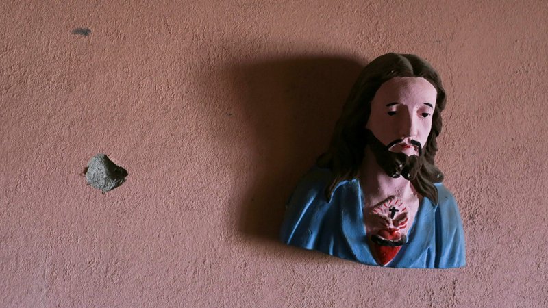 A bust of Christ hangs from a wall next to a bullet impact at an abandoned home near Aguililla, Mexico, April 23, 2021. Pope Francis has sent a letter of encouragement to the town's residents as they confront battling drug cartels. (CNS photo/Alan Ortega, Reuters)