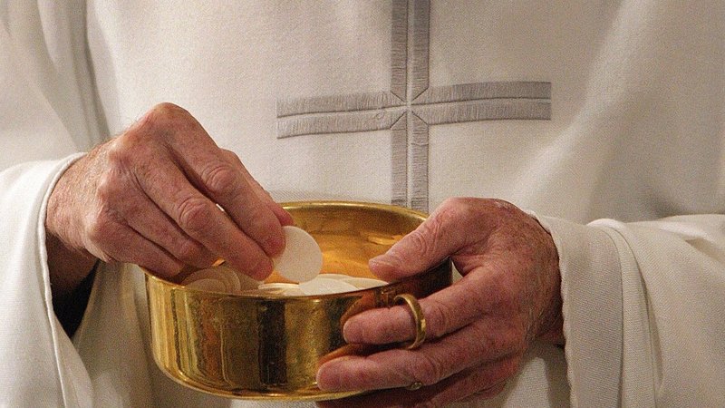 A priest prepares to distribute Communion during Mass in Washington in this 2011 photo. (CNS photo/Bob Roller)