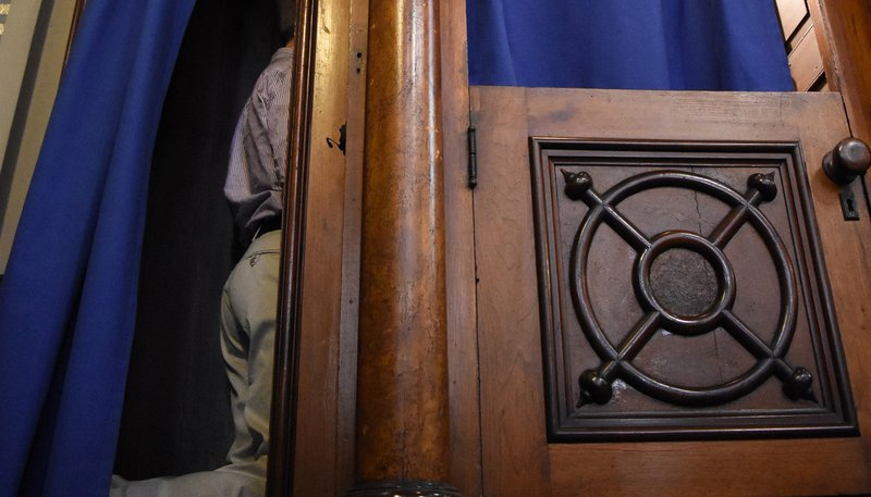 A man makes his confession in a confessional booth at Old St. Mary's Church in Detroit on Feb. 29. (CNS/Mike Stechschulte, The Michigan Catholic)