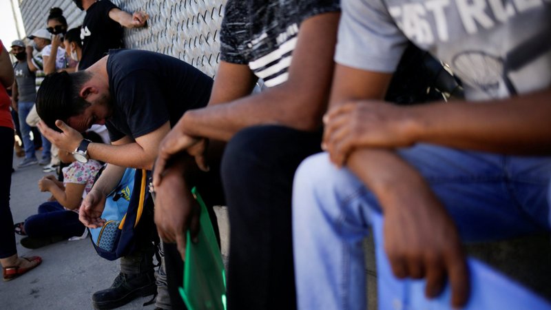Migrants in the "Remain in Mexico" program queue outside the premises of the National Migration Institute in Ciudad Juarez, Mexico, are seen July 8, 2020. (CNS photo/Jose Luis Gonzalez, Reuters)