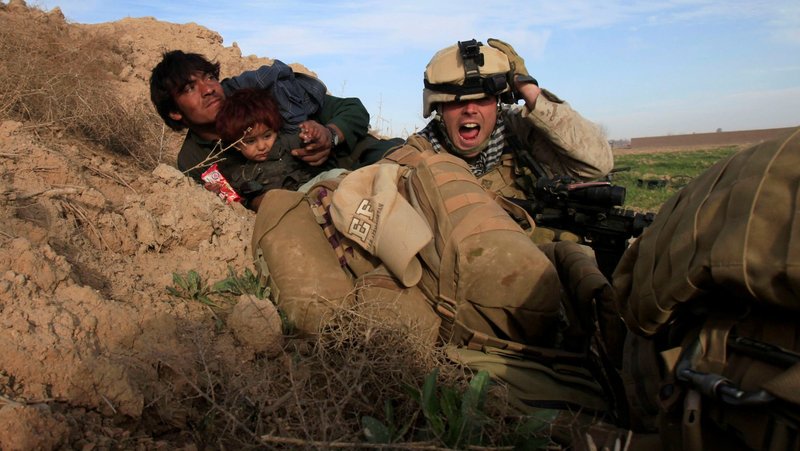 U.S. Marine Lance Cpl. Chris Sanderson, from Flemington, N.J., shouts as he tries to protect an Afghan man and his child after Taliban fighters opened fire in Marjah, Afghanistan, in this Feb. 13, 2010, file photo. (CNS photo/Goran Tomasevic, Reuters)