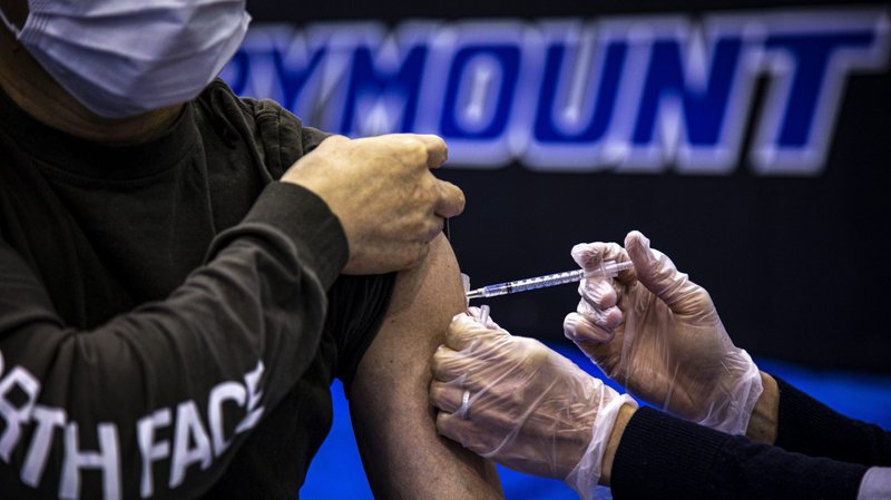 A health care worker administers the Pfizer COVID-19 vaccine to a Marymount University student in one of the athletic buildings on the Catholic university's Arlington, Va., campus, during a coronavirus vaccine clinic April 21, 2021. (CNS photo/Chaz Muth)