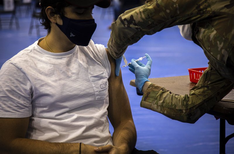 A health care worker administers the Pfizer COVID-19 vaccine to a Marymount University student in one of the athletic buildings on the Catholic university's Arlington, Va., campus, during a coronavirus vaccine clinic April 21, 2021. CNS photo/Chaz Muth)