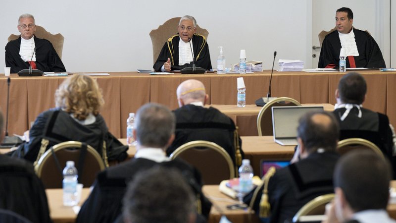 The judges of the Vatican City State criminal court -- Venerando Marano, Giuseppe Pignatone and Carlo Bonzano -- face dozens of lawyers in a makeshift Vatican courtroom July 27, 2021, as the trial of 10 defendants in a financial malfeasance case begins. Cardinal Angelo Becciu is among the defendants. (CNS photo/Vatican Media)