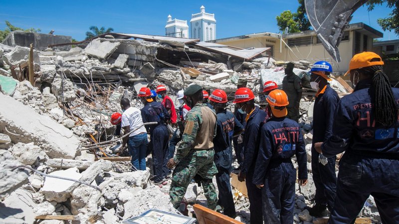 Members of a rescue and protection team clean debris from a house in Les Cayes, Haiti, Aug. 15, 2021, following a magnitude 7.2 earthquake the previous day. (CNS photo/Ralph Tedy Erol, Reuters)