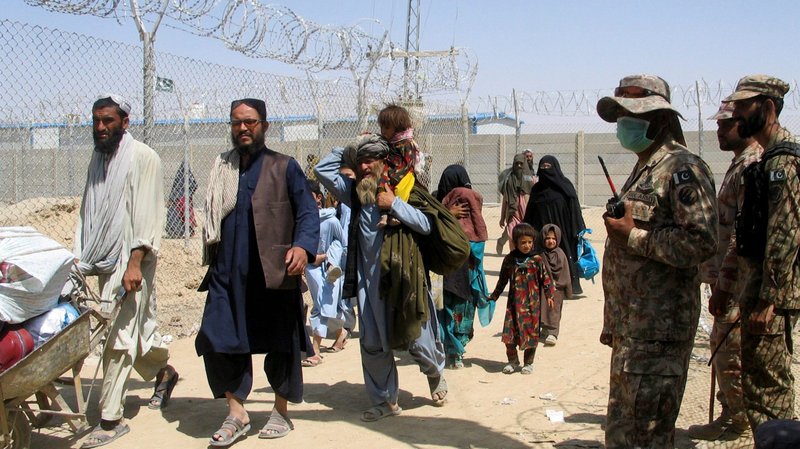 People arriving from Afghanistan make their way through the Friendship Gate crossing point at the Pakistan-Afghanistan border town of Chaman, Pakistan, Aug. 19, 2021. (CNS photo/Saeed Ali Achakzai, Reuters)