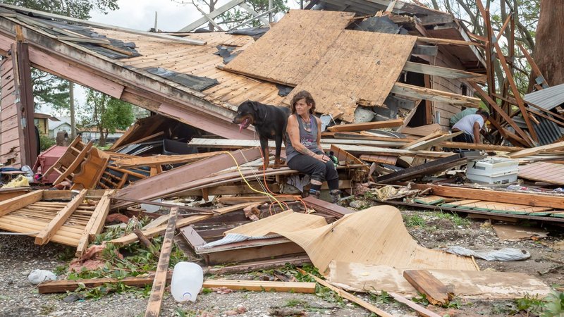 Fran Tribe sits with her dog, Dave, outside a home in Houma, La., Aug. 30, 2021, after Hurricane Ida made landfall. (CNS photo/Scott Clause, USA TODAY Network via Reuters)