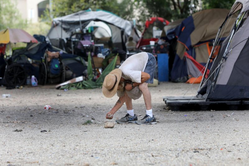 A homeless man sifts through debris at an an encampment under a highway in Austin, Texas, Sept. 7, 2021. In 2020, a one-day count estimated that there more than 3,000 homeless people in Austin. Almost 70% of the homeless population in Austin are people who are living with a disability. (CNS photo/Bob Roller)